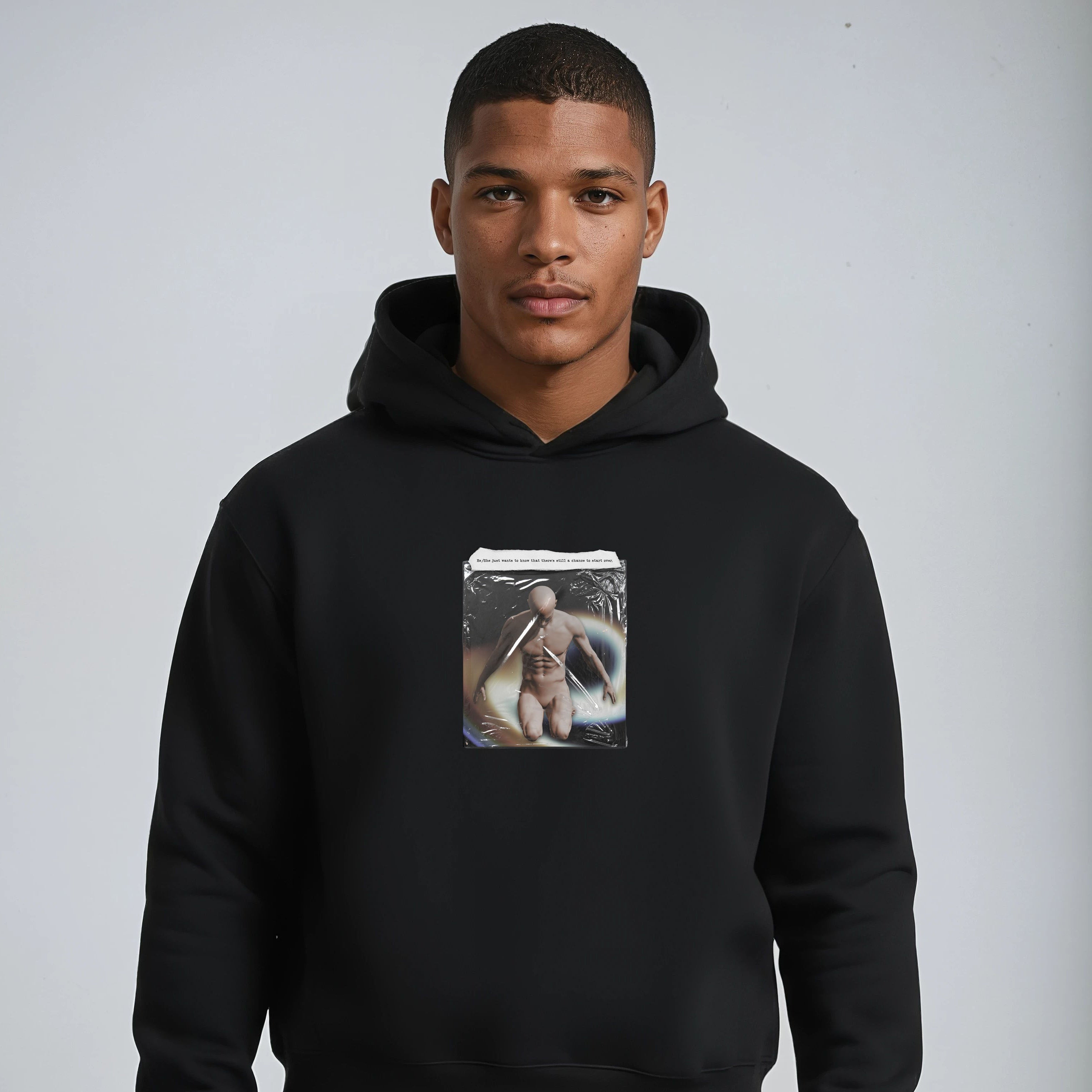 Person wearing a black hoodie with a graphic design on a plain background