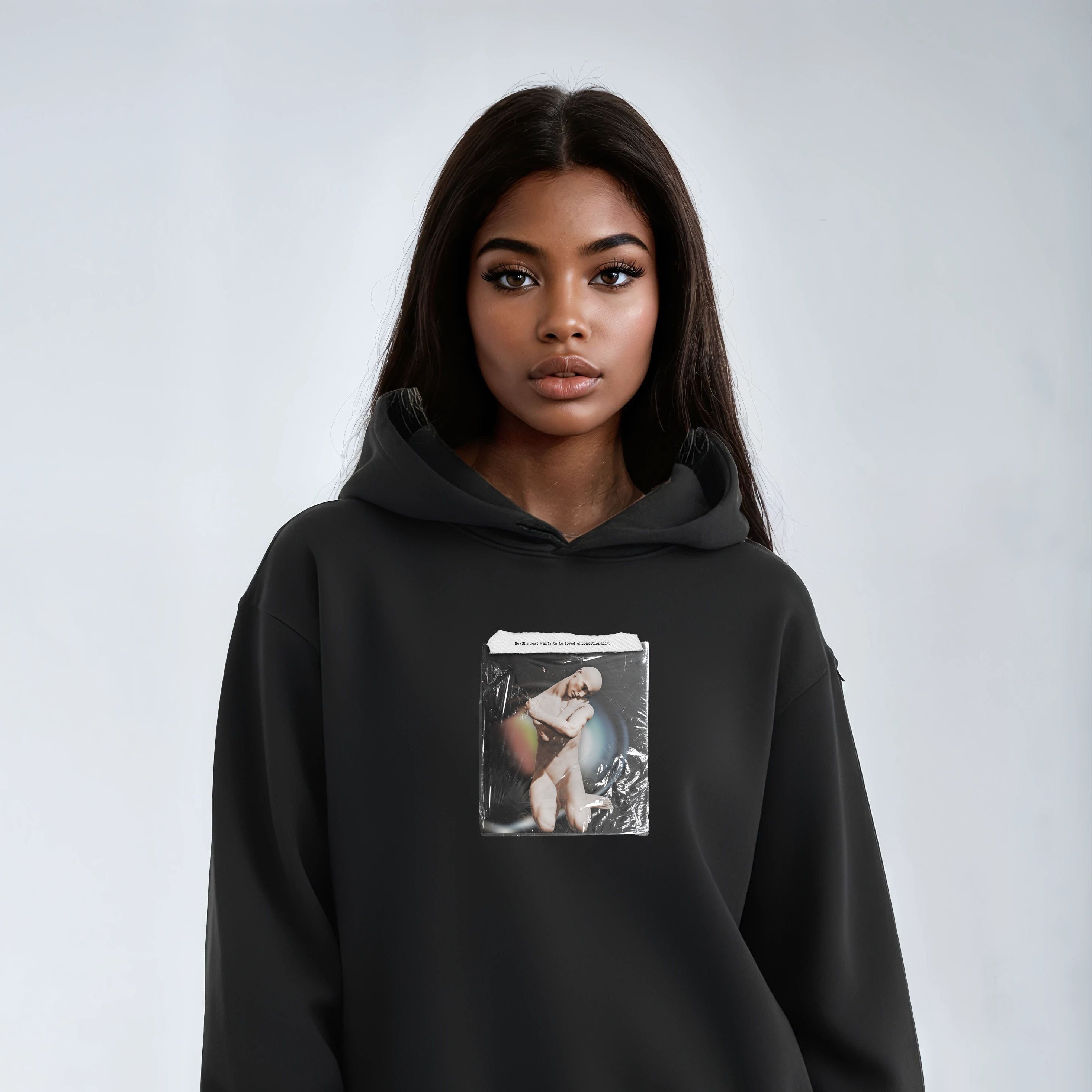 Person wearing a black hoodie with a graphic design on a plain background