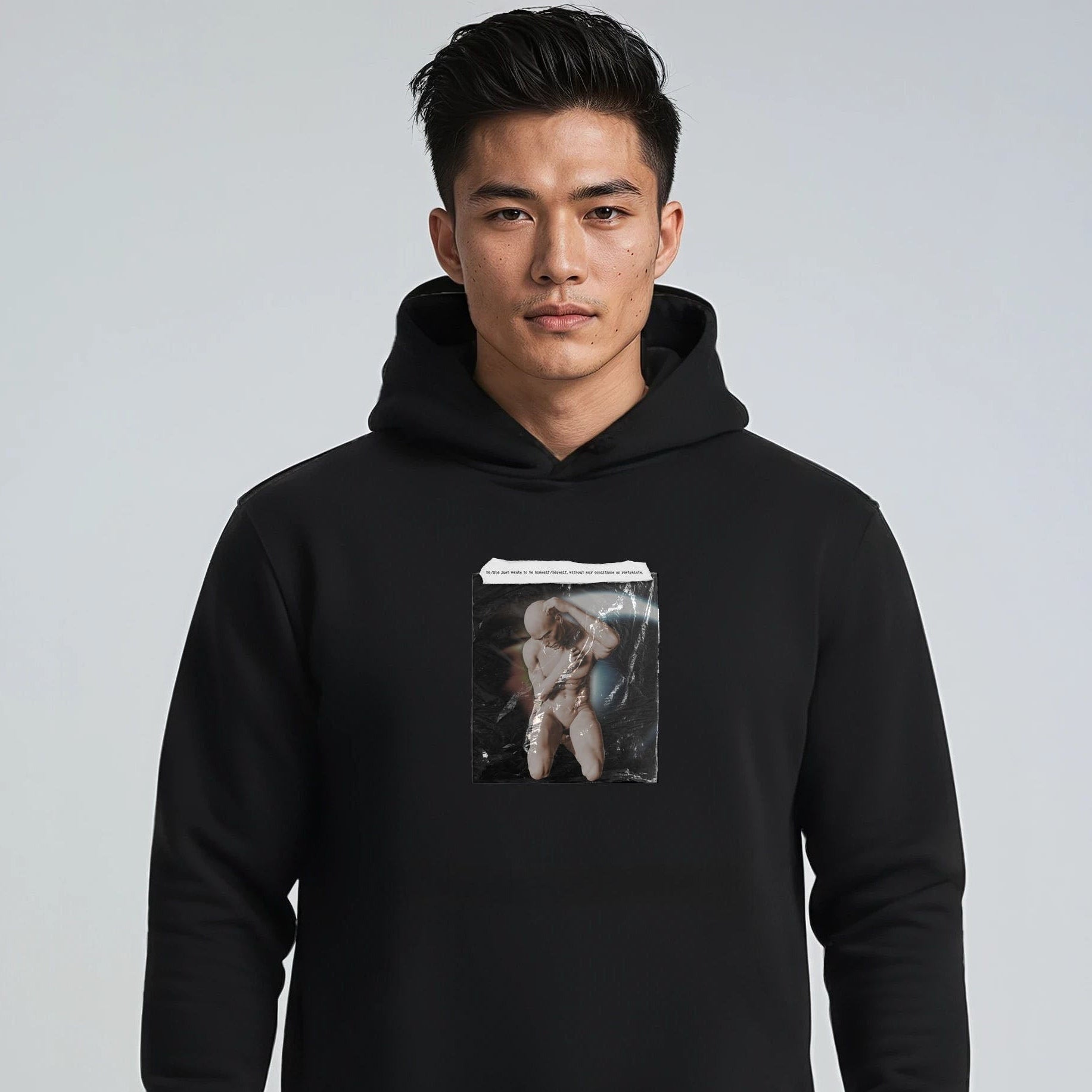 Person wearing a black hoodie with a graphic design on a plain background