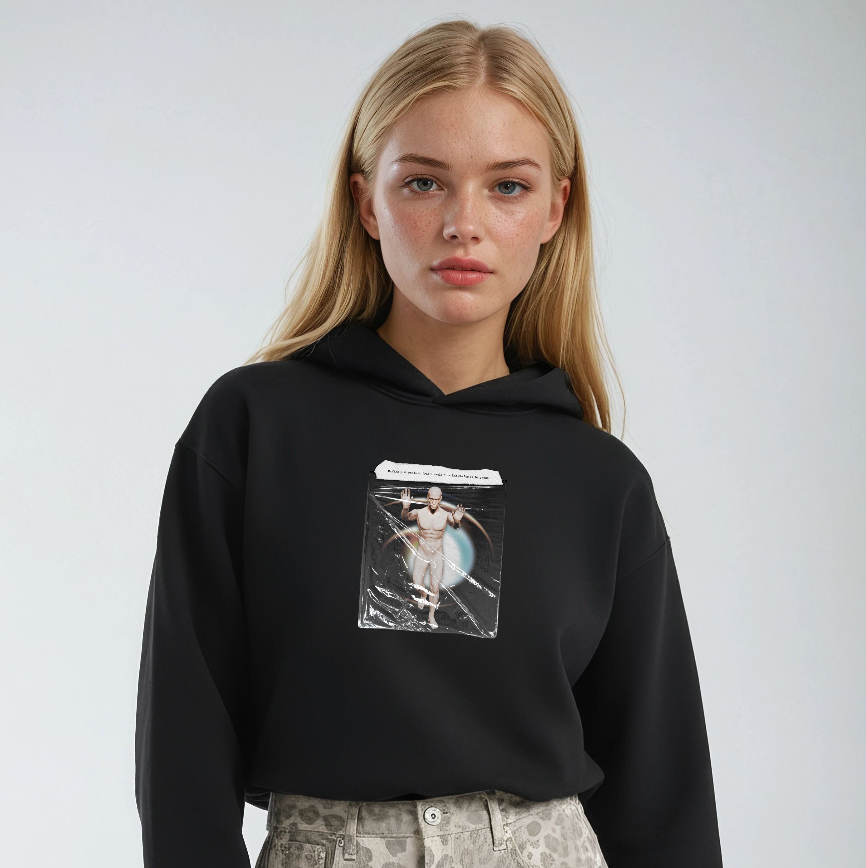 Person wearing a black hoodie with a graphic design on a plain background