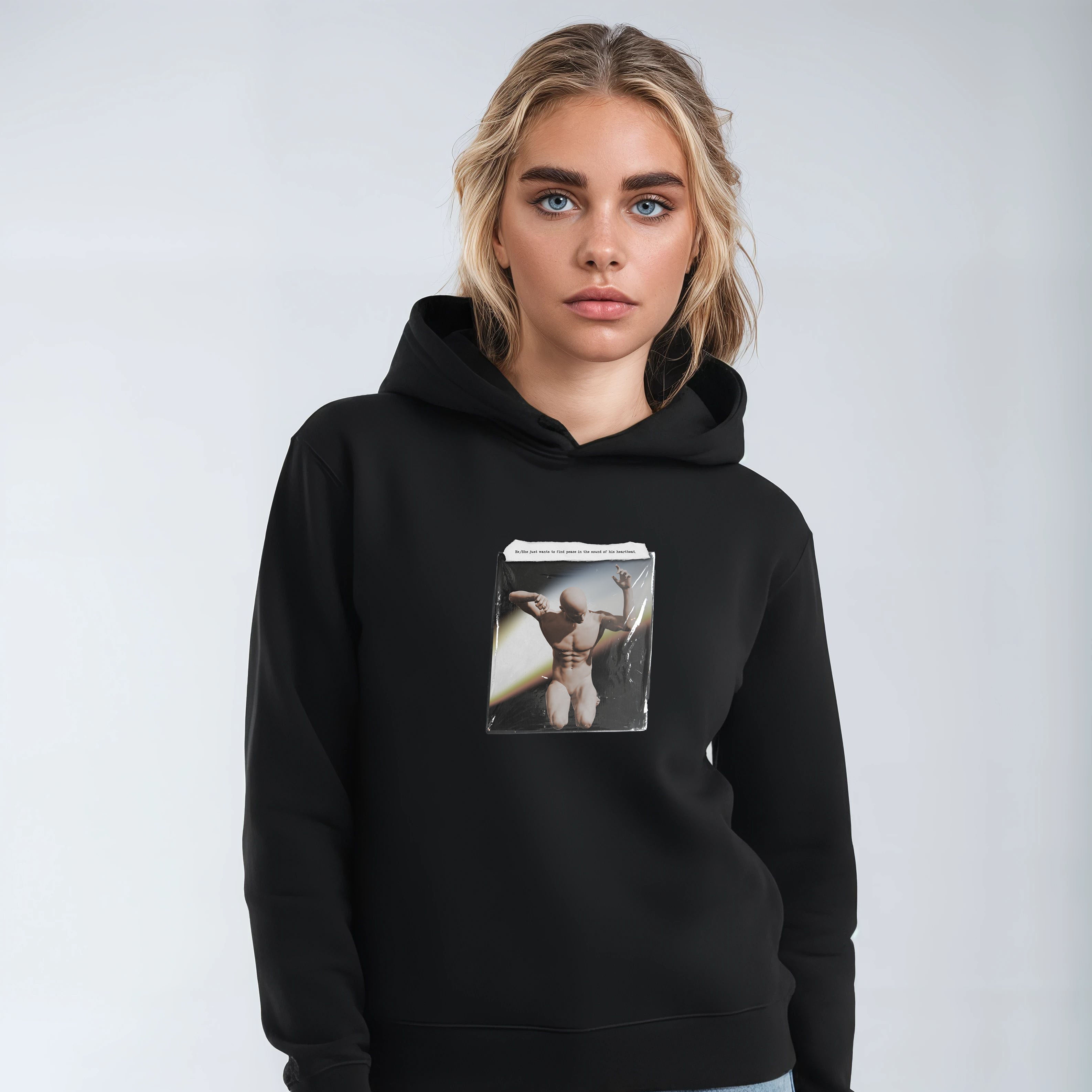 Person wearing a black hoodie with a graphic design on a plain background