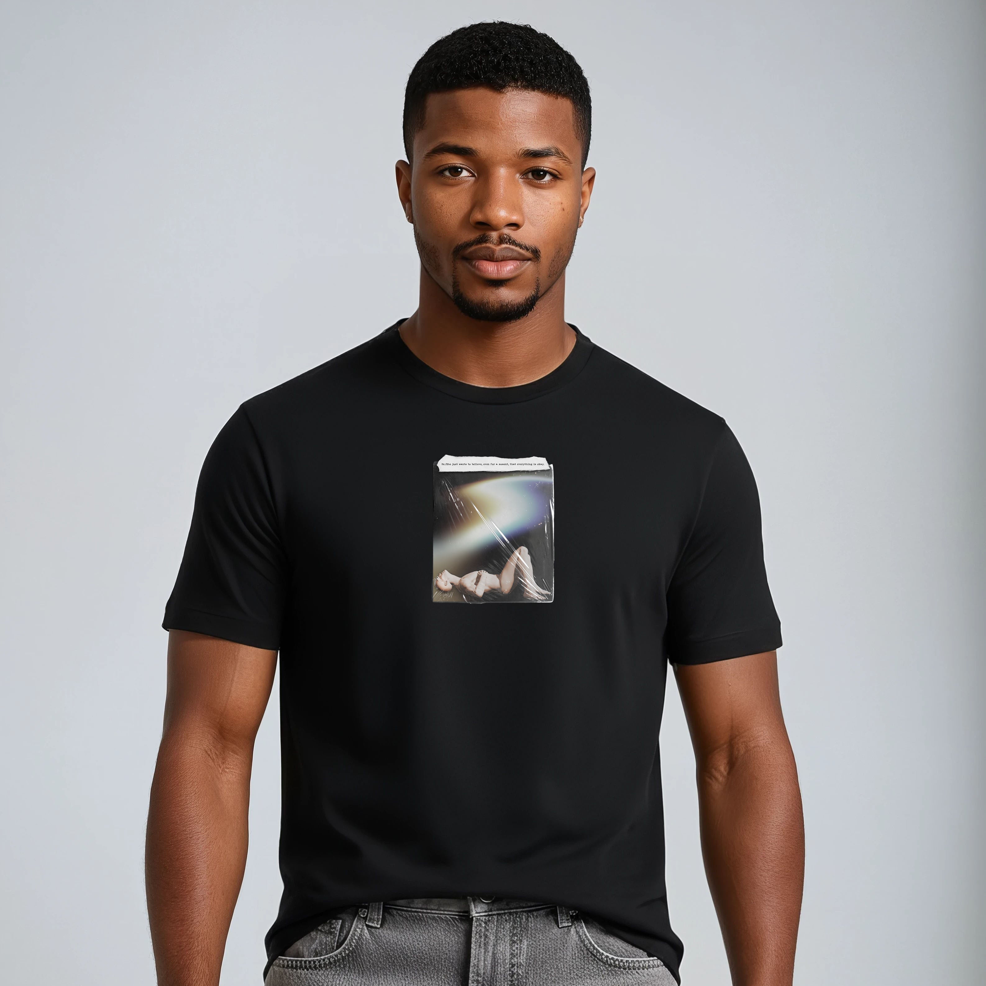 Man wearing a black t-shirt with a graphic design on a plain background