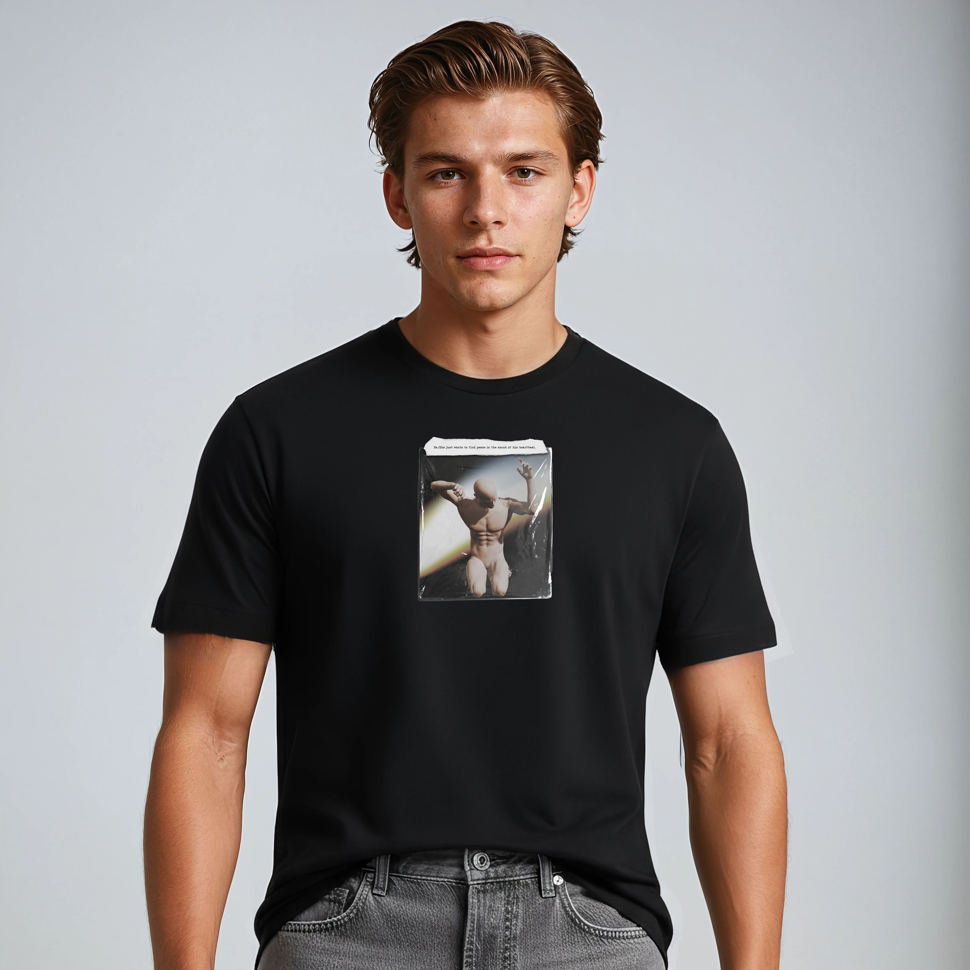 Man wearing a black t-shirt with a graphic design on a plain background