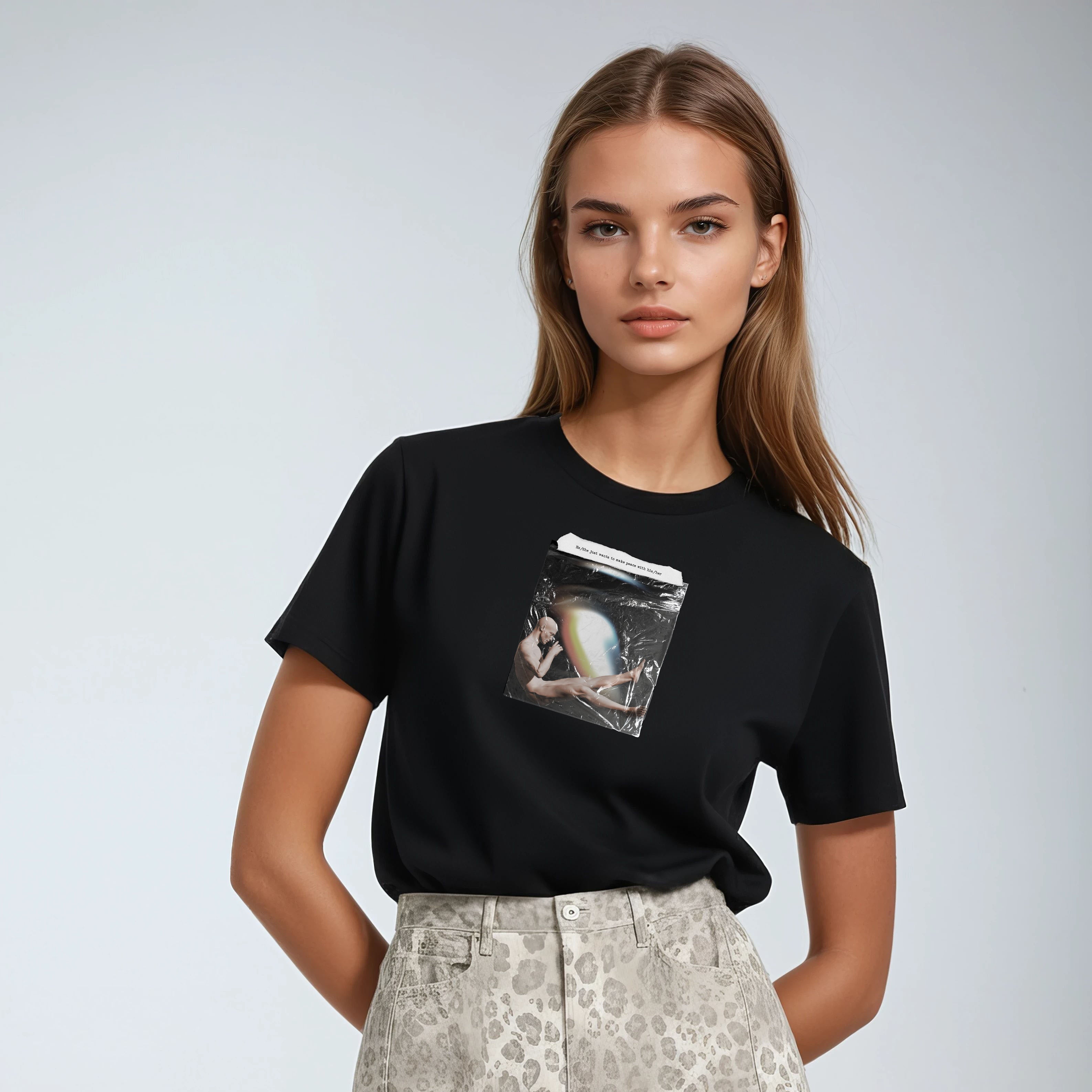 Woman wearing a black t-shirt with a graphic design on a plain background