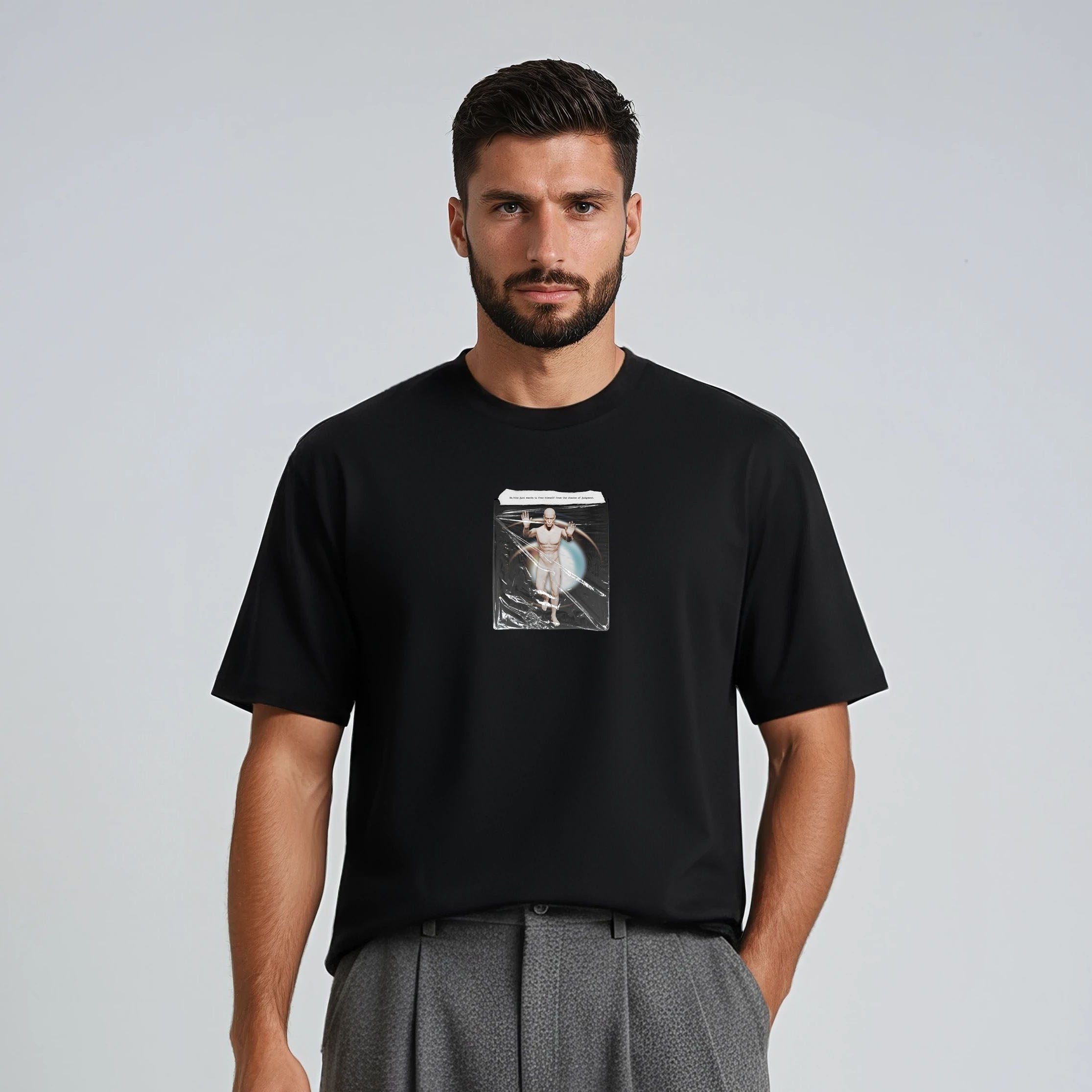 Man wearing a black t-shirt with a graphic design and gray pants on a light gray background