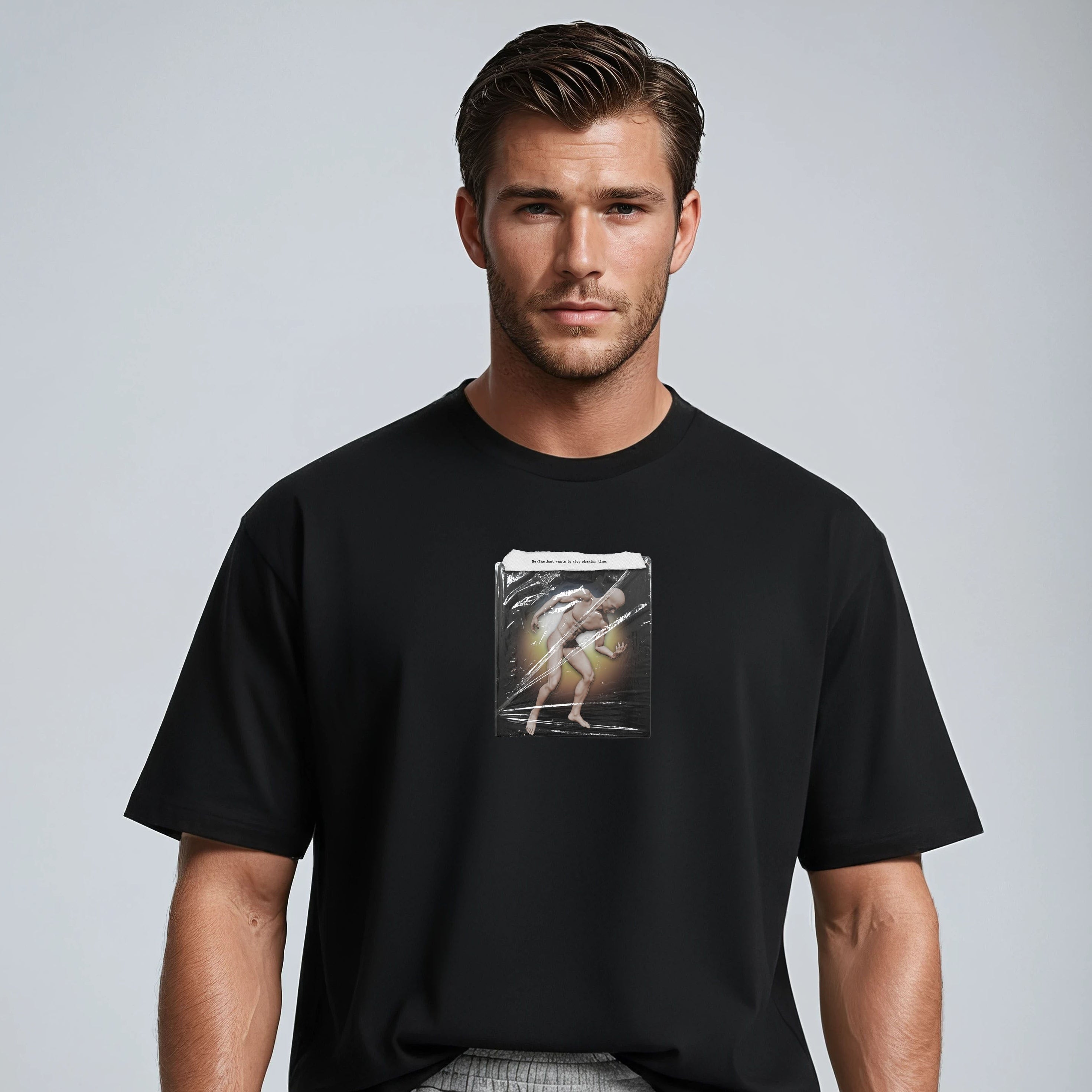 Man wearing a black t-shirt with a graphic design on a plain background