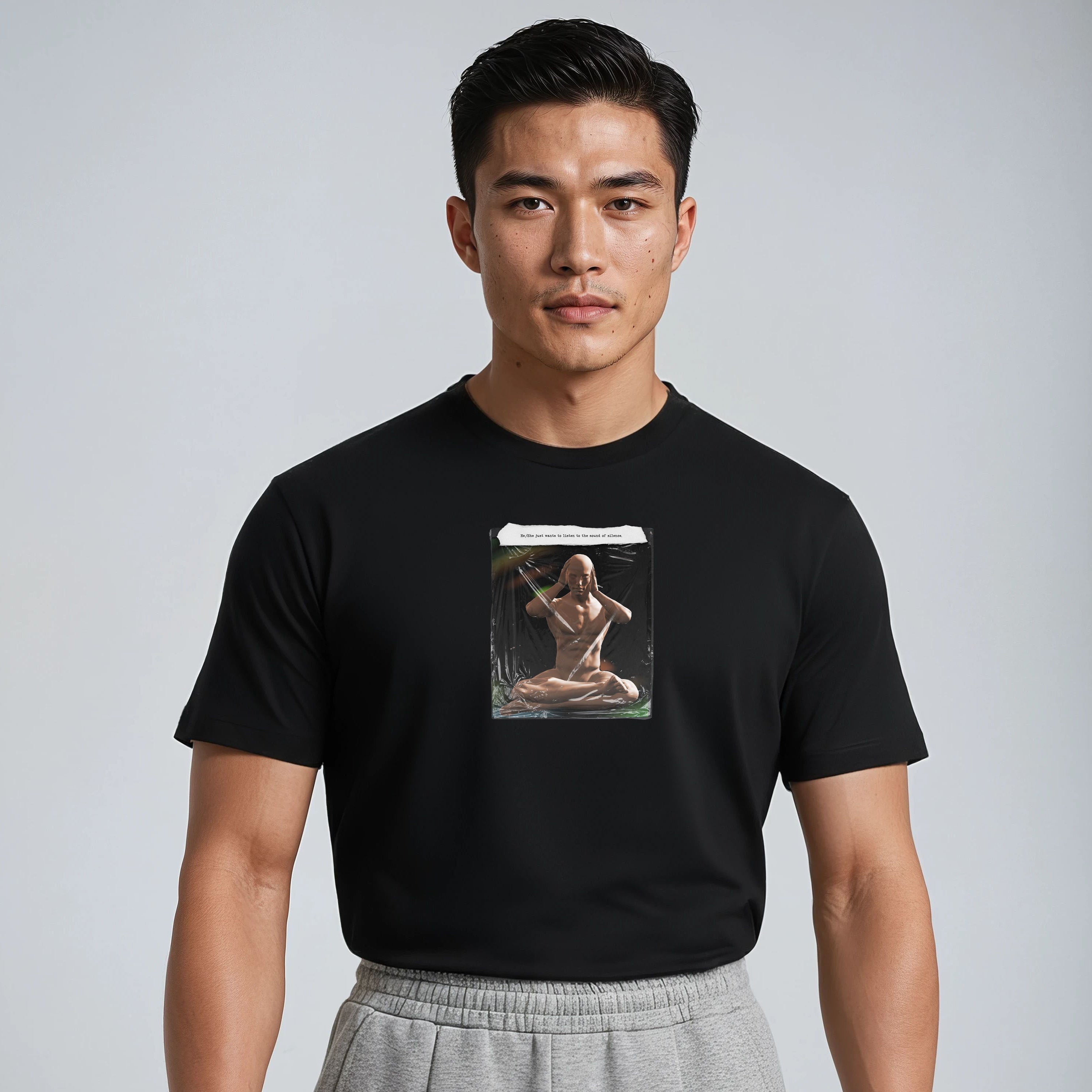 Person wearing a black t-shirt with a graphic design on a plain background